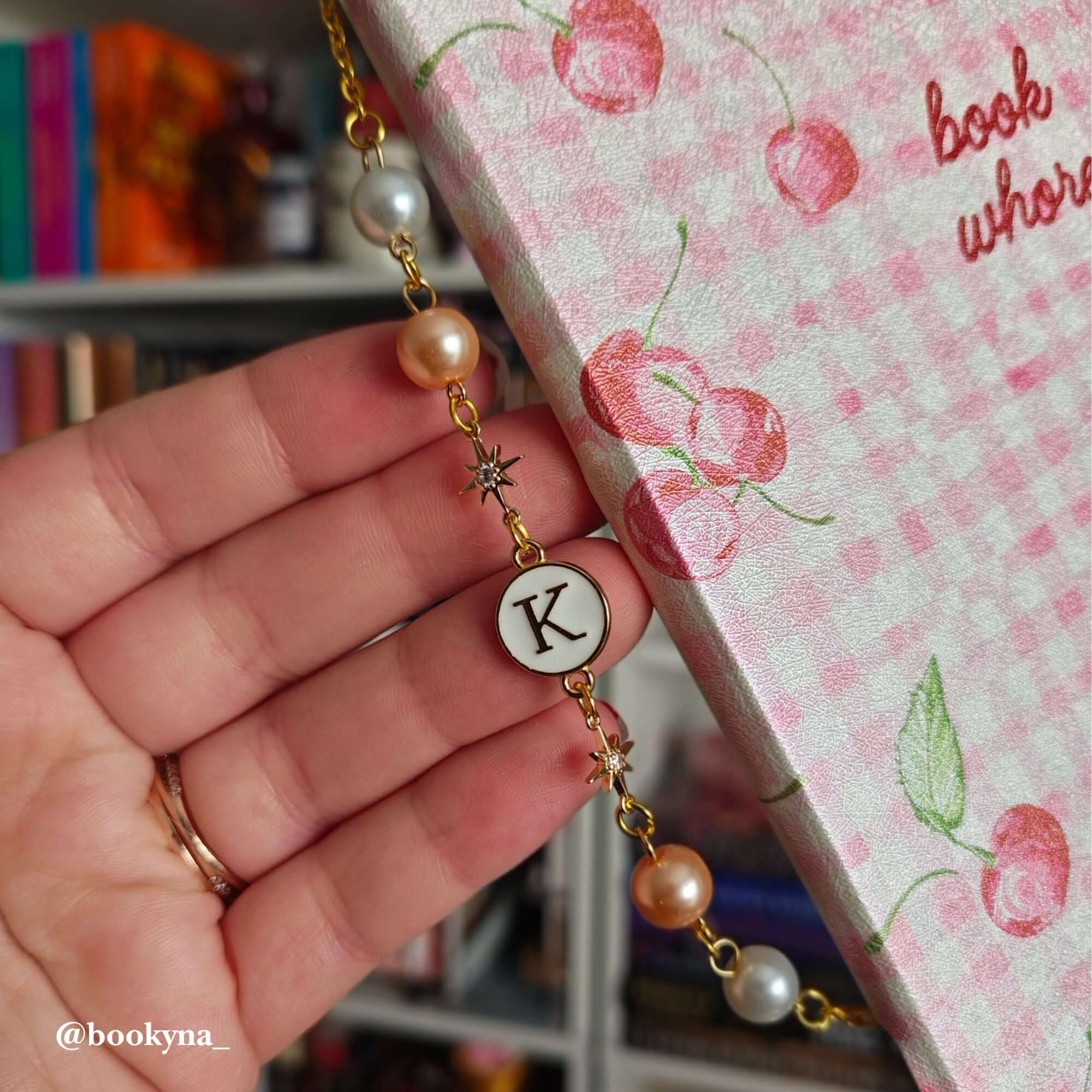 Personalized Kindle cover jewelry featuring a dainty pearl and engraved initial.