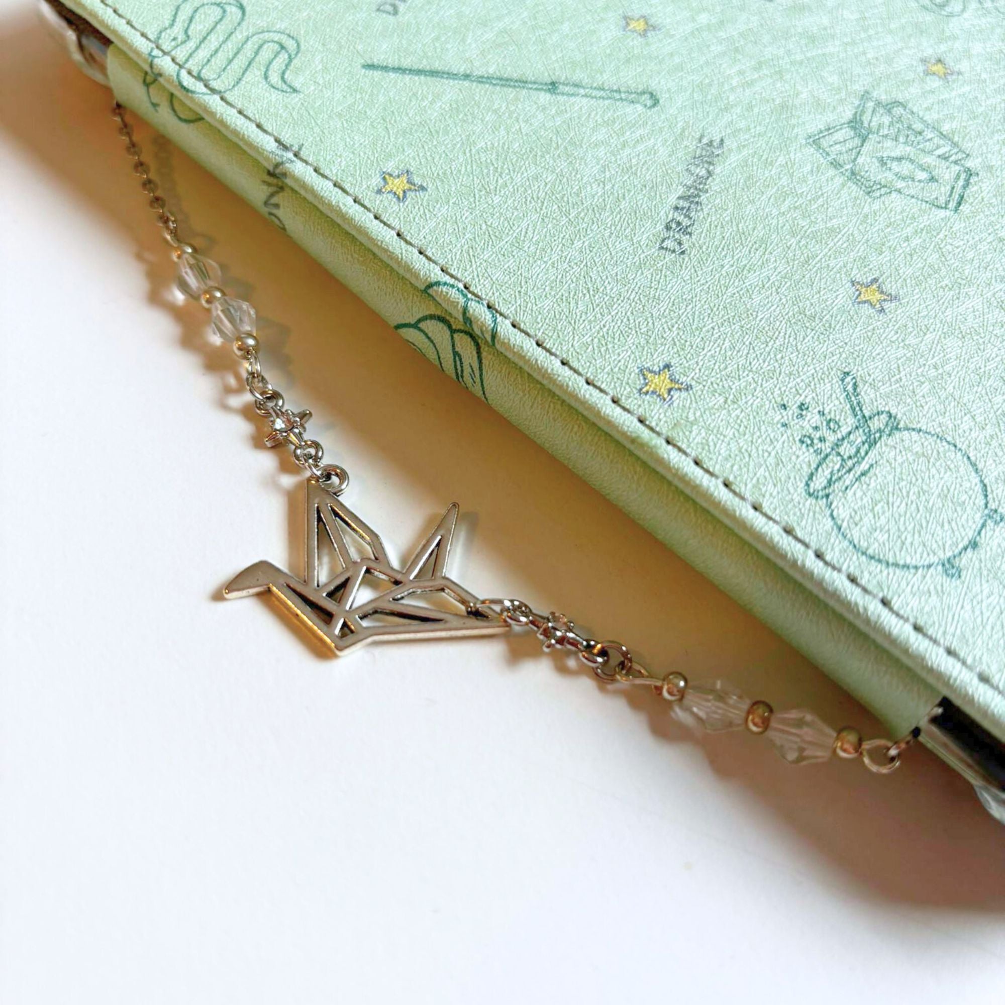 Elegant silver paper crane charm with delicate beads, perfect merch for dramione lovers.